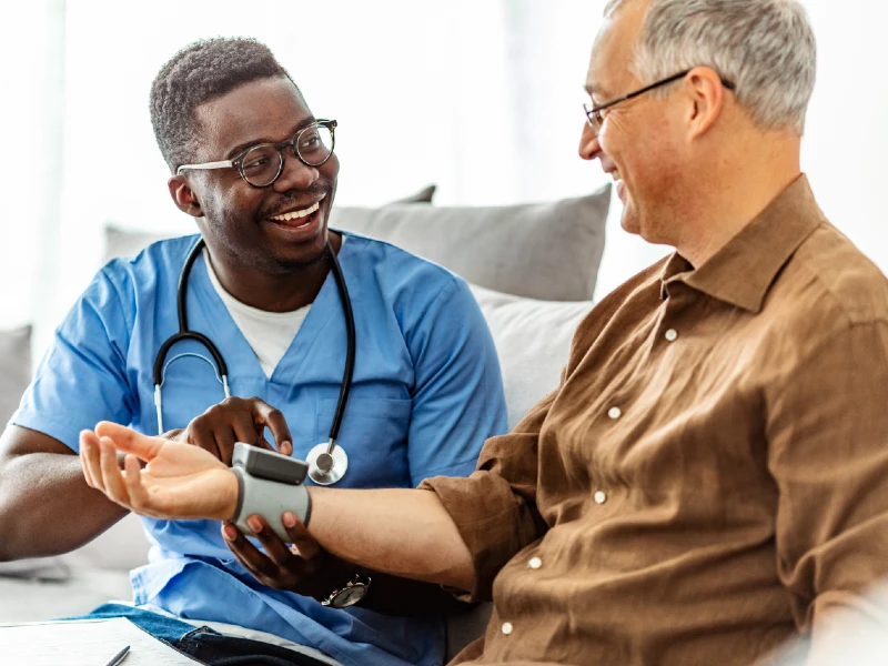 A smiling male student working with a patient