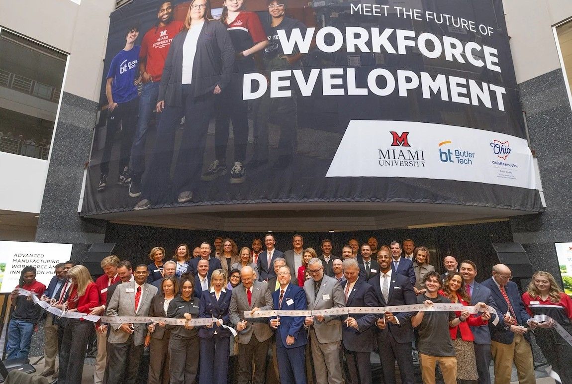 President Crawford, Randy Thomas, and other Miamians gather behind a large ribbon as it is cut