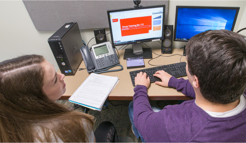 Two students working on a computer in the tutoring and learning center.