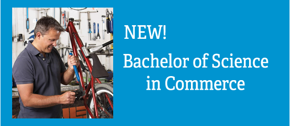 Small business owner working in his cycle shop. Text: New: Bachelor's of Science in Commerce