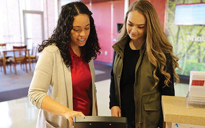 A staff member helping to check a student in at the one stop on the Middletown campus.
