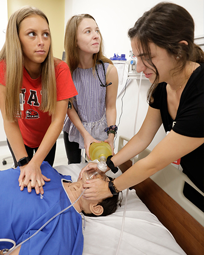 3 nursing students working on a sim during a lab.