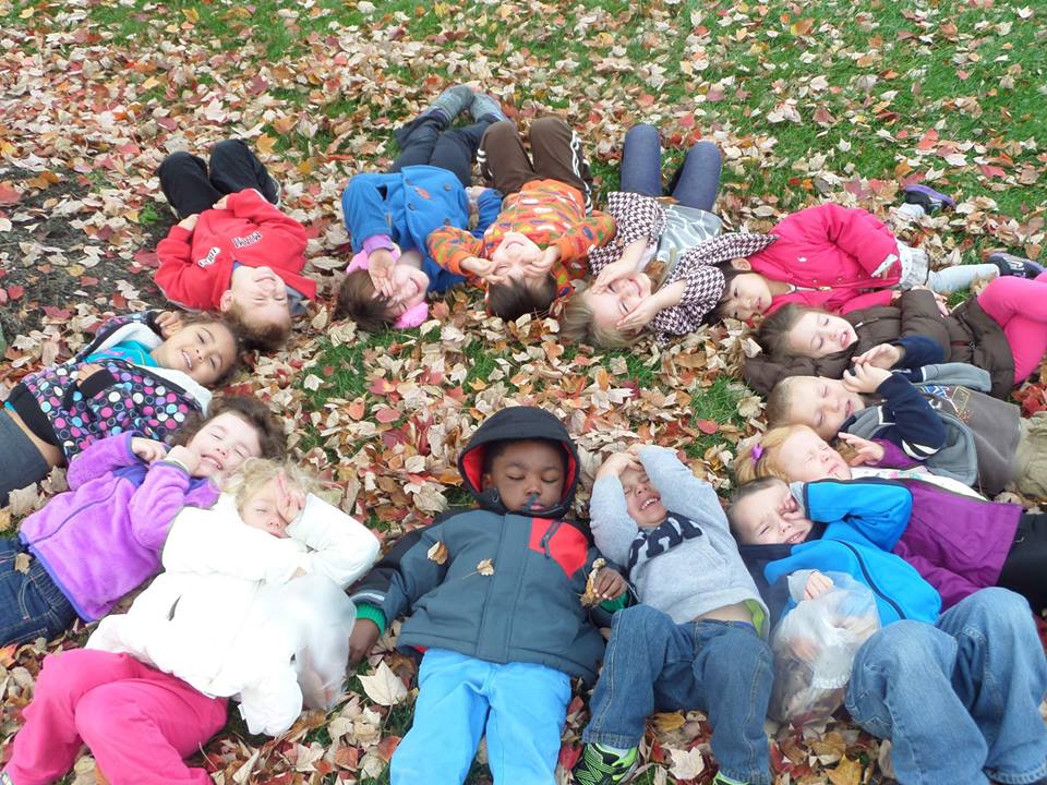 Campus Kids laying in the grass in a circle