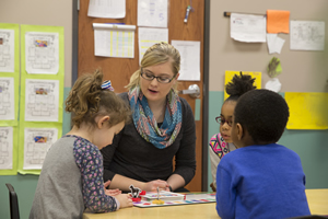 Pre-k student instructor playing a game with children.