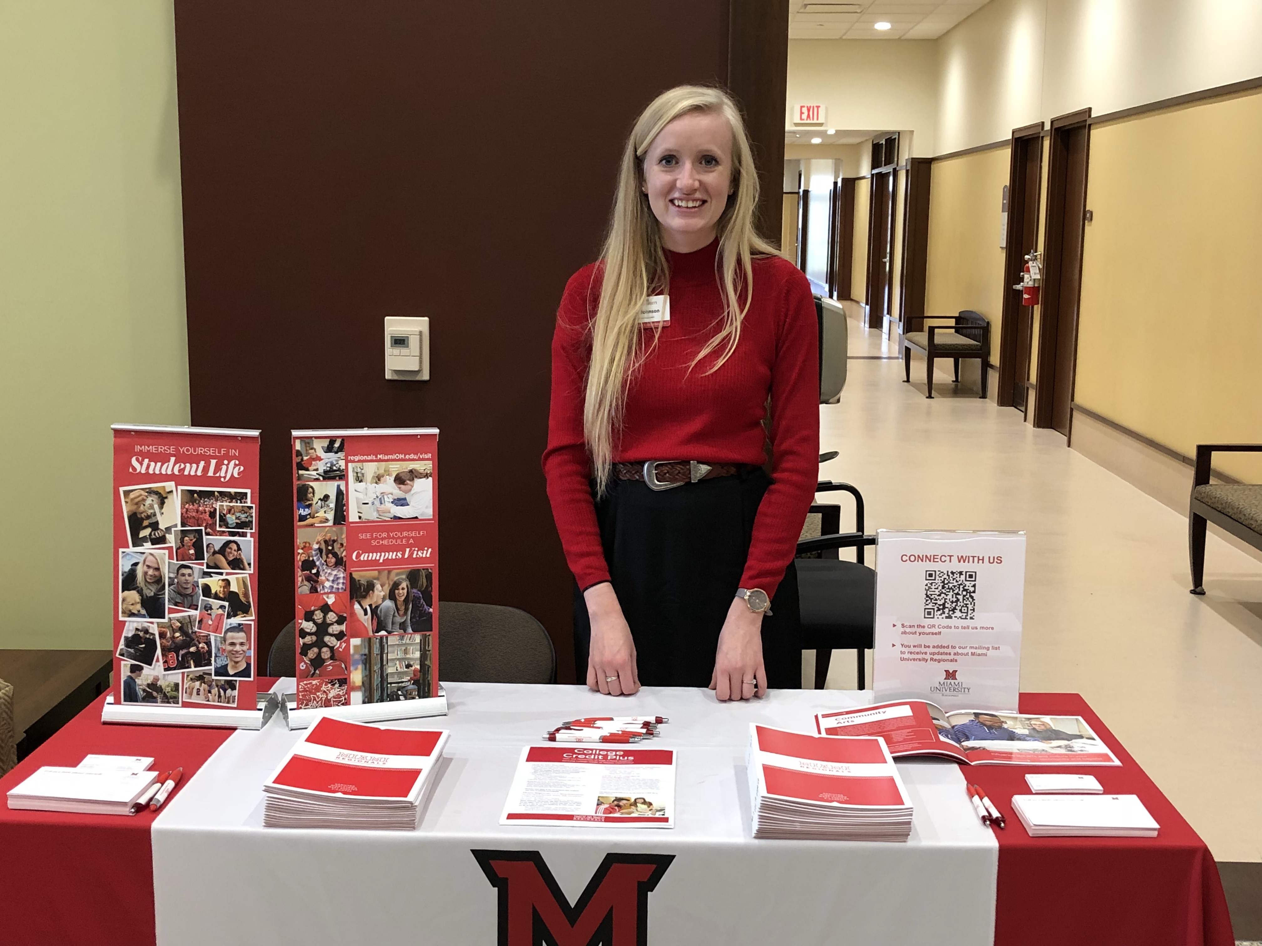 Photo of Emily Johnson standing at a Miami table.