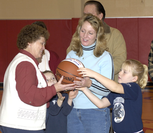 Photo of Anna being recognized by Coach Miller with her daughter Adrianna