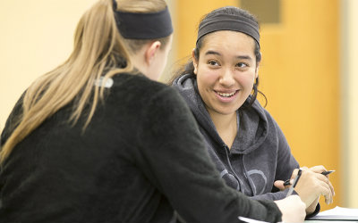 A female student tutoring another female student.