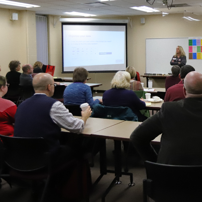 faculty and staff listening to a speaker