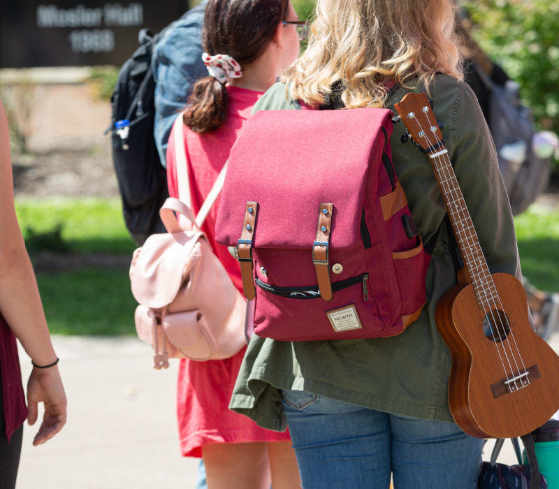 A student carrying her violin on her back.