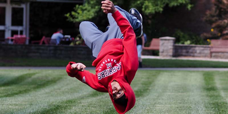 Student doing a backflip in the quad