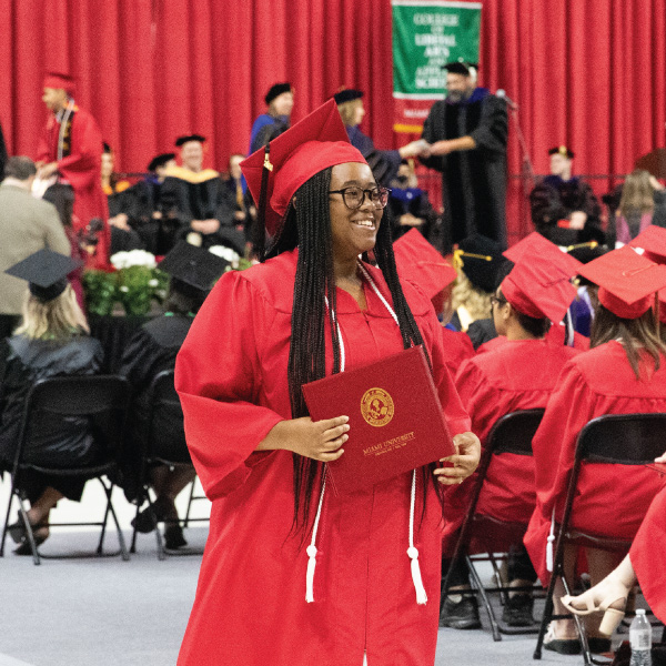 2024 Early College Academy graduate walking away after receiving her diploma at graduation.