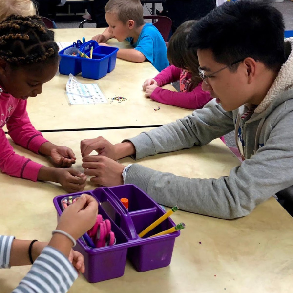 Making beaded crafts with local elementary students.