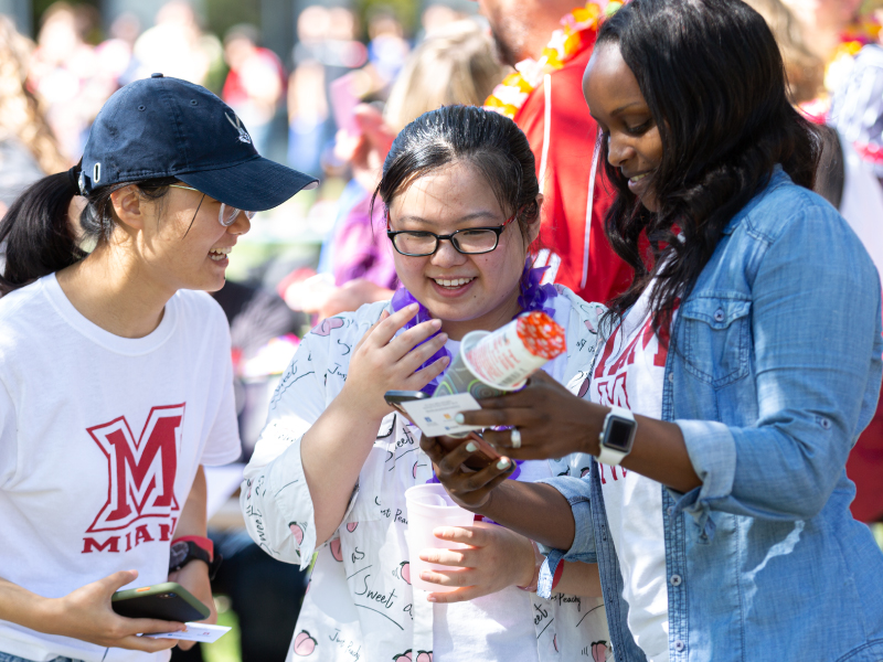 Tres estudiantes sonríen en el exterior durante el Festival de Otoño en Middletown. 