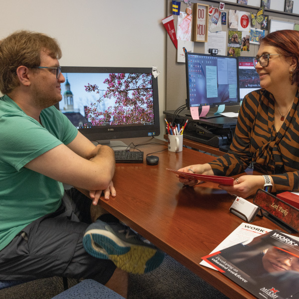 A student meeting with an academic advisor to talk about scheduling classes.