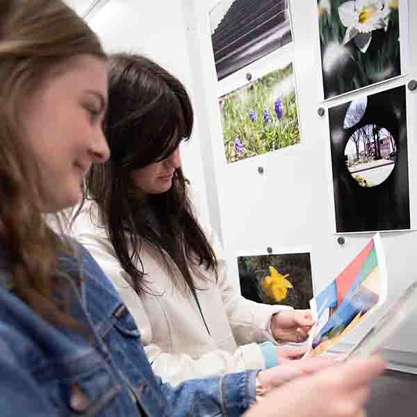 Students reviewing hard copy proofs of their photos