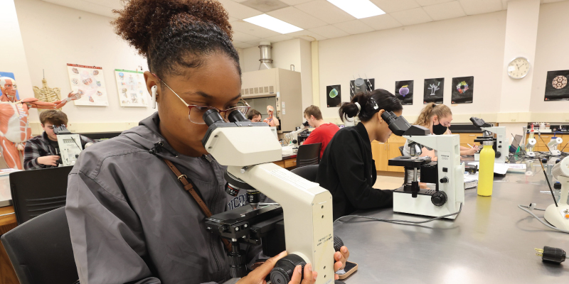Student looking into a microscope