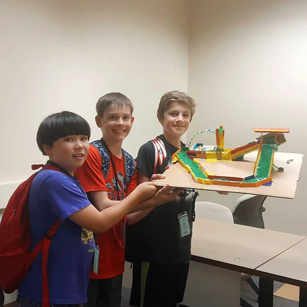 A group of campers displaying their amusement park ride engineering project