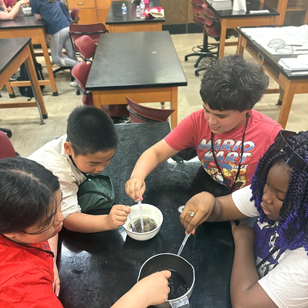 Four campers using eyedroppers in an experiment