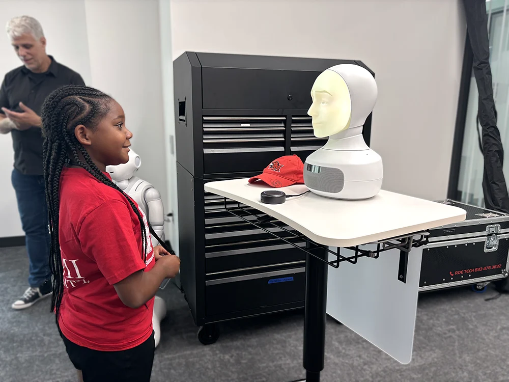 A STEAM Studio camper interacting with a robot
