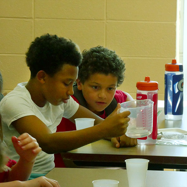 Two campers measuring liquids