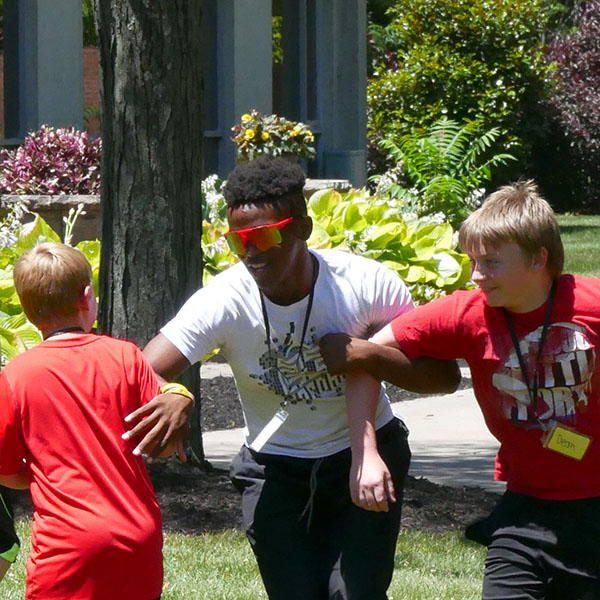 Leader in training playing a game of tag with campers