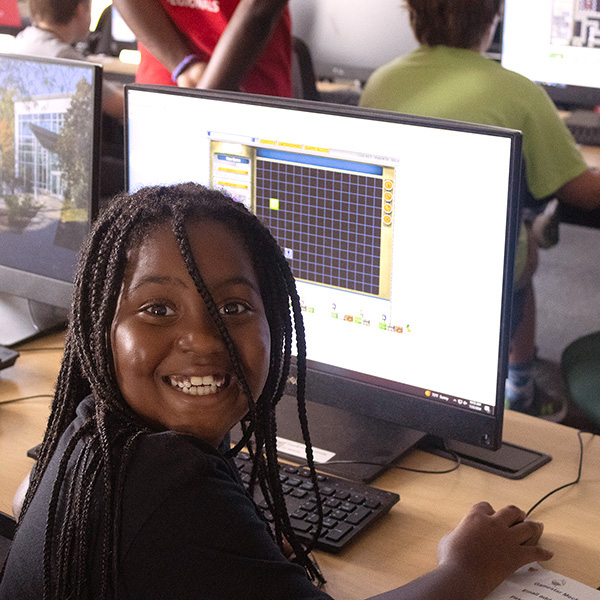 A young woman camper learning to code a game