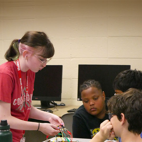 STEAM Counselor showing campers how to connect circuits