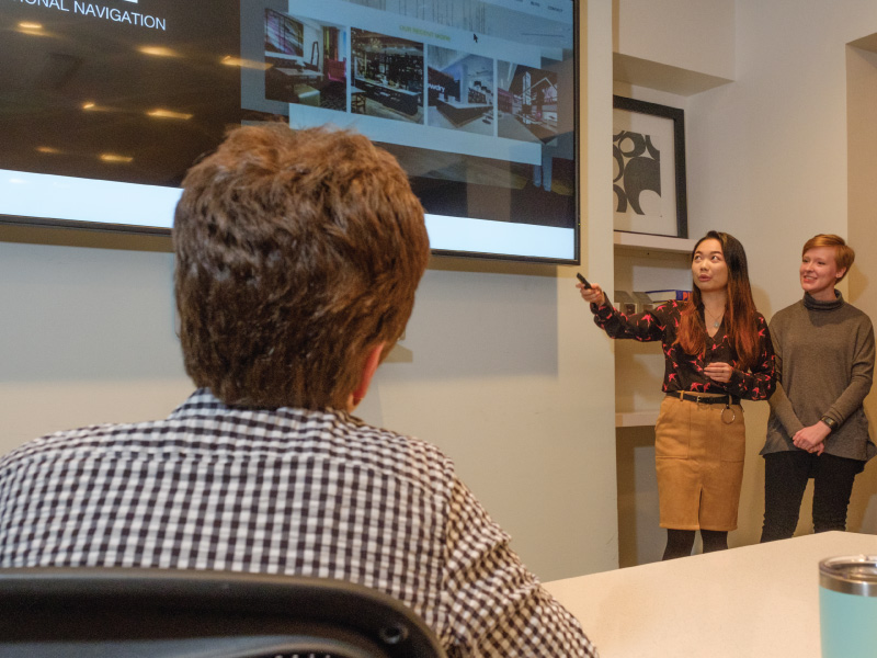 2 students giving a presentation to an employer