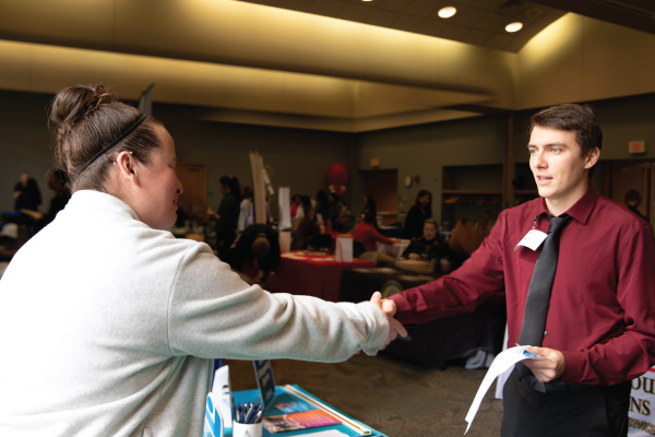 A student shaking an employers hand during the career fair.
