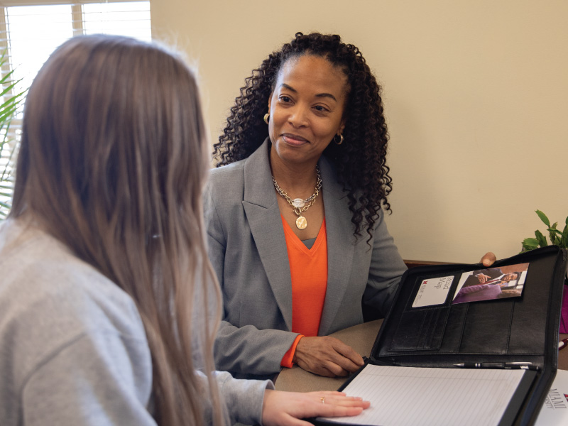 Career Services Center staff member meeting with a student and going through a portfolio.