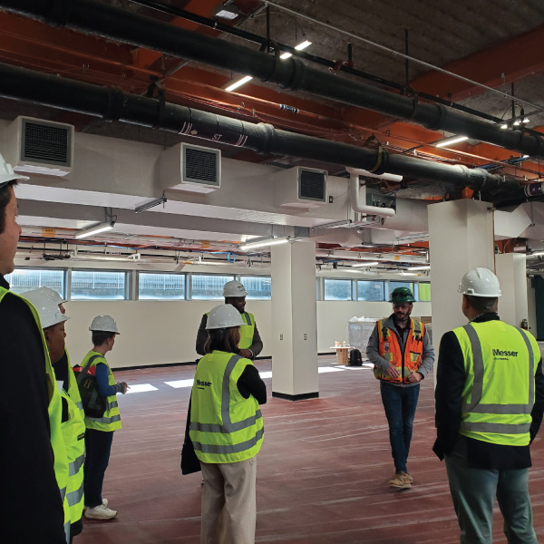 Group of people in hard hats and yellow vests touring the subtractive lab