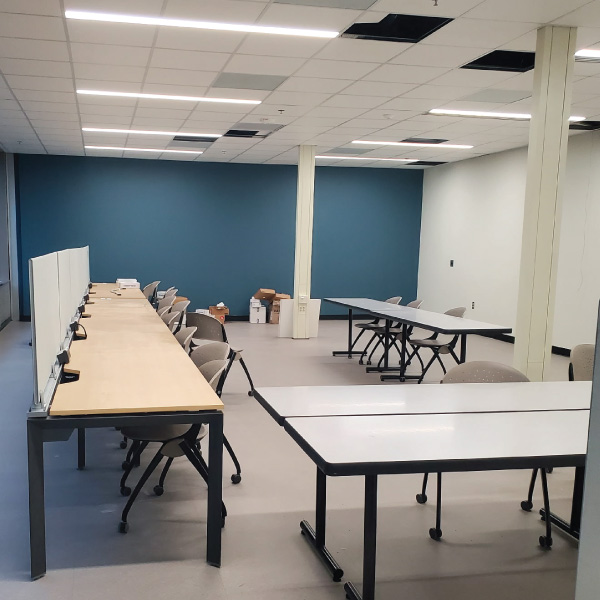 Classroom with long tables and chairs. 