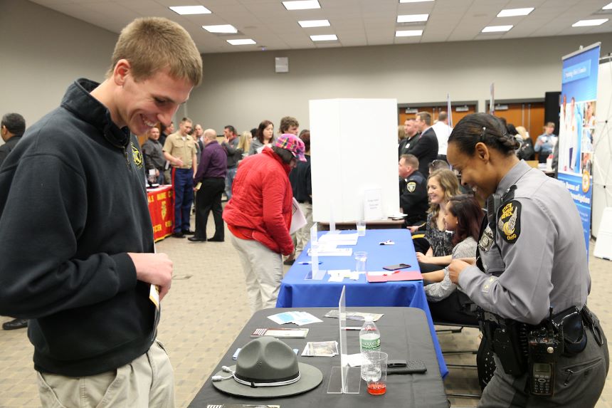 Student looks at a table of materials during the symposium.
