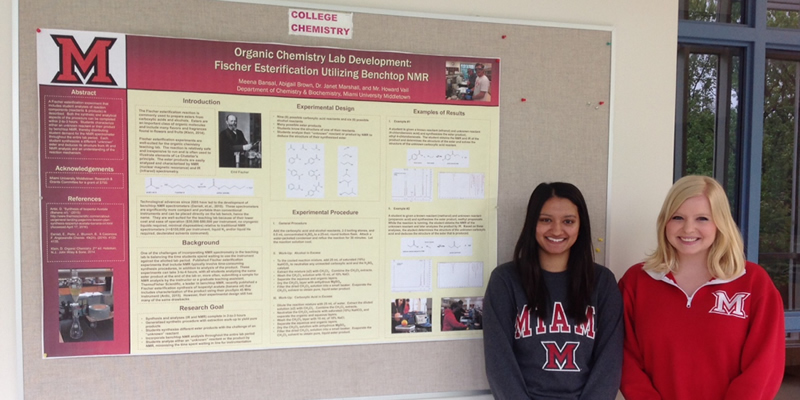 Meena Bansal and Abby Brown stand in front of their research project poster.