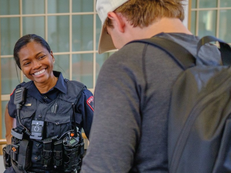 Criminal justice student speaks with a law enforcement professional during a career-connected learning experience.