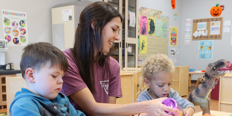 Future early childhood educator works with young children during a classroom learning activity.