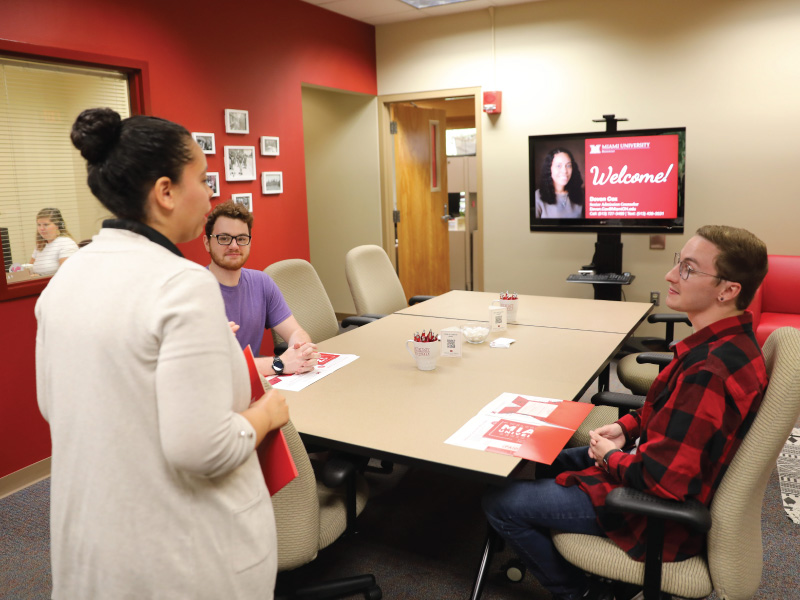 2 students talking to a Miami University Regionals admission counselor. 