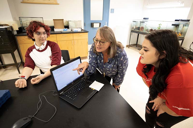 Barb Oswald working in lab with Early College Academy students