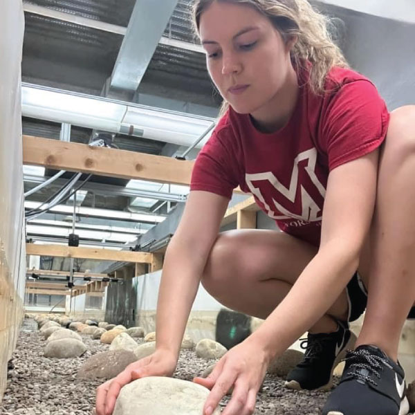 Sarah working in the flume setting up the boulders