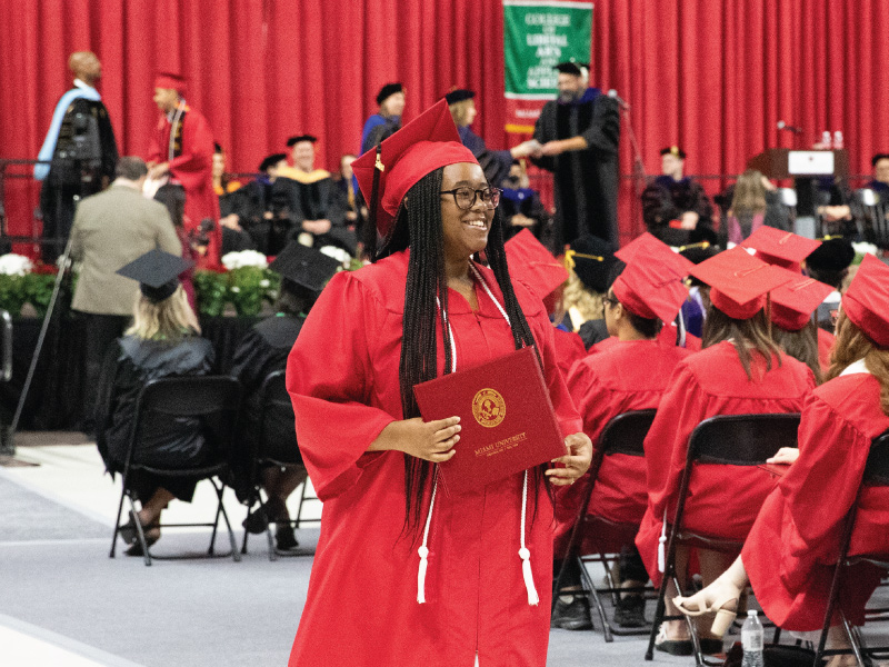 2024 Early College Academy graduate walking away after accepting her diploma at commencement.