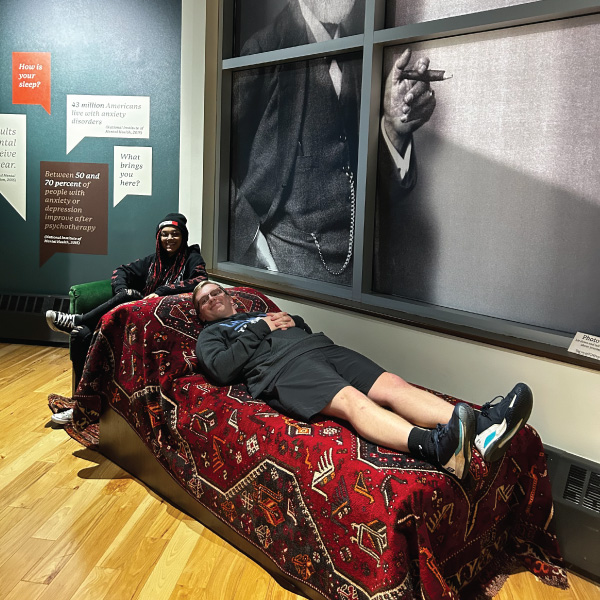 Student laying on a bed at the museum.