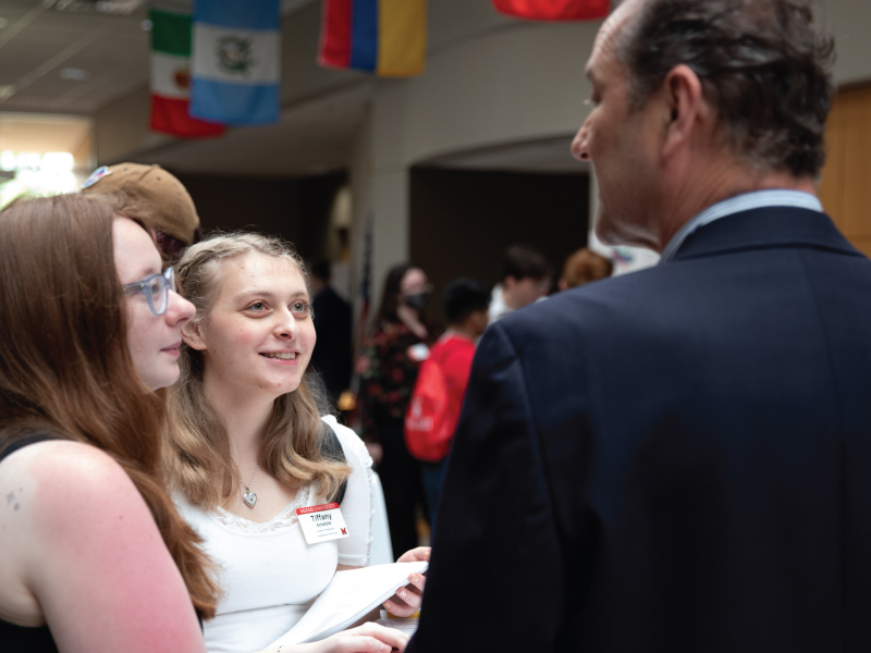 ENT student ambassadors talking with a community member during the ENT senior design day