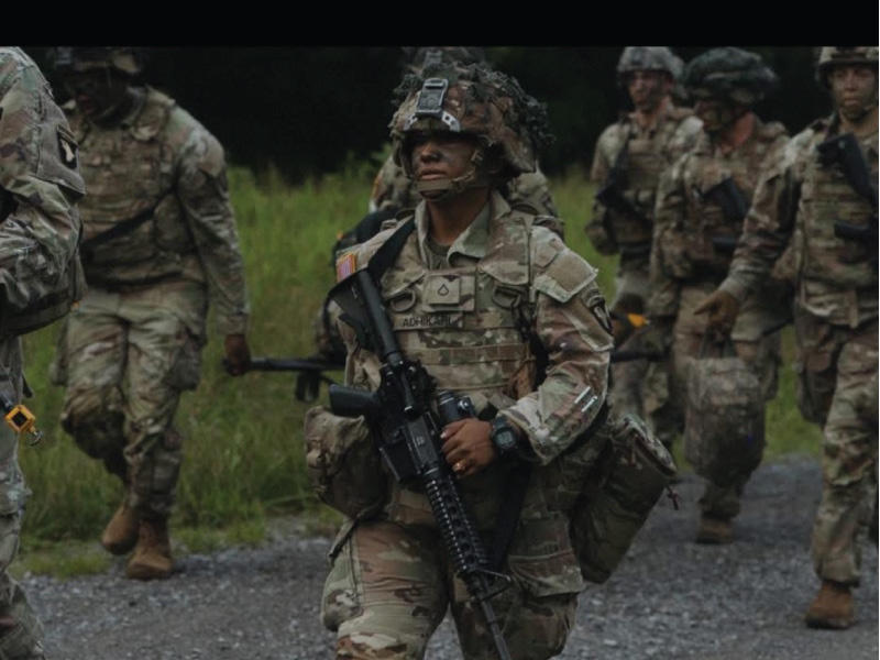 Ganga Adhikari in her Army attire walking with other soldiers.