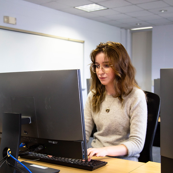 A woman programmer writing code on a computer