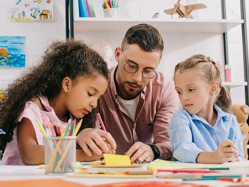 A preschool teacher with two students