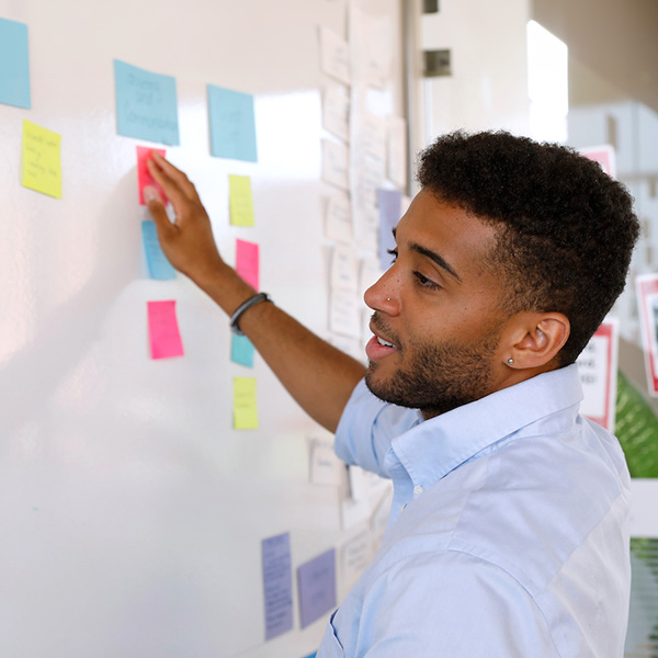 A person organizing a project with sticky notes and Agile techniques