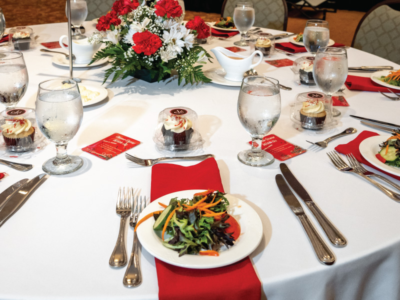 Table with red napkins and glassware. 