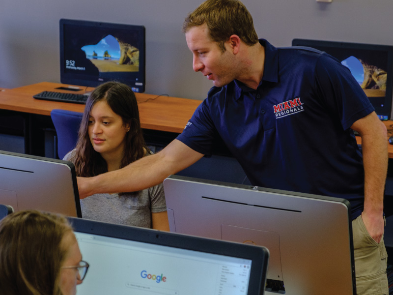 Jacob Robinson Director of Technology Services helping a student in the computer lab.