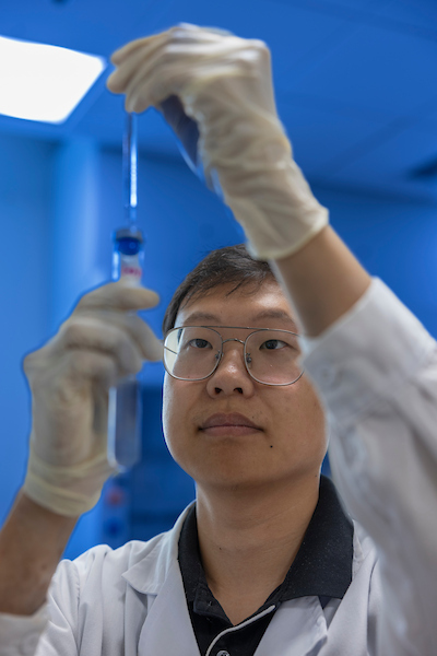 Research student looking at a pipet
