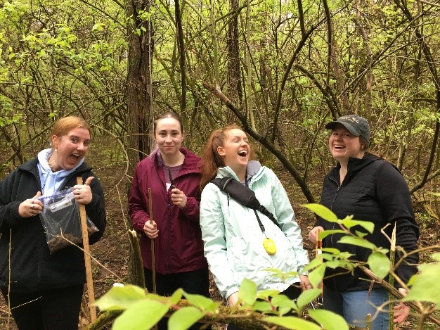 Abby Hay with three other students, laughing in a natural area of Miami University.